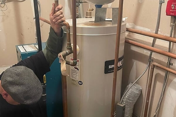 man fixing a hot water heater